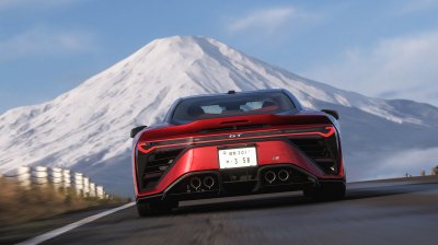A rear view of a supercar blasting down the highway with Mount Fuji dominating the skyline ahead.