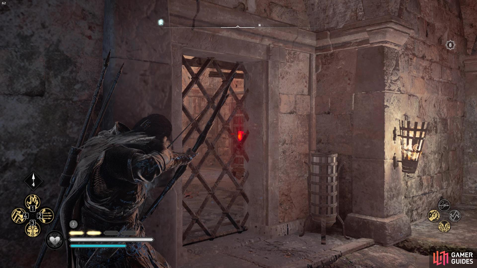 once you've exploded the stone barricade you'll be able to shoot the door lock through the bars.