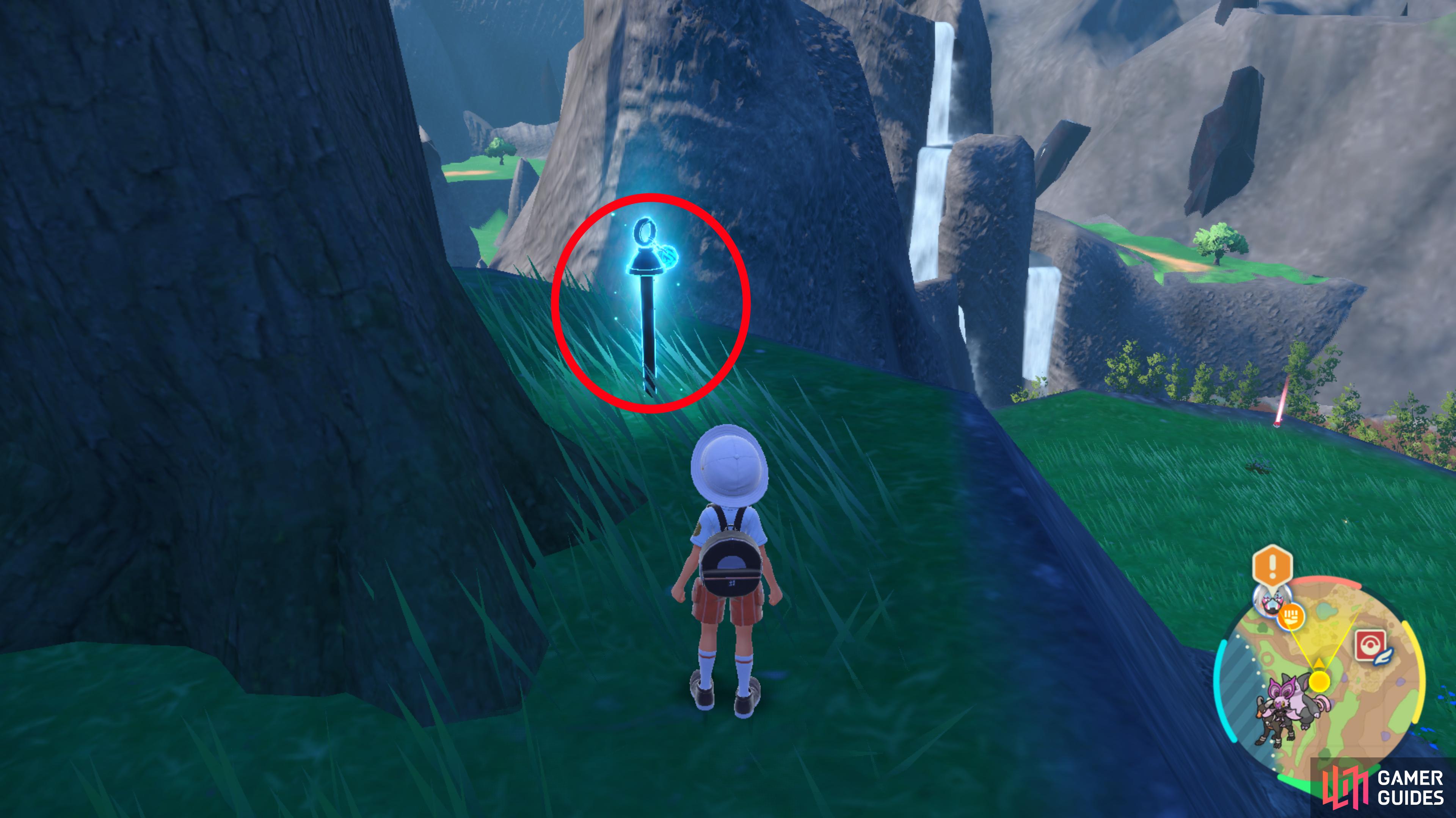 the blue stake can be found next to the tree when facing the waterfall.