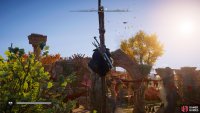 You’ll find the flying paper atop a tall wooden pole, attached to the red canopies around the longhouse.