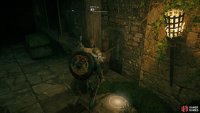 Use the mechanism to lift the gate, then jump down through the hole beneath the wooden barricade.