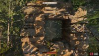 To the right of the boulders, you&rsquo;ll find a piece of wall with a window through it. This will show you the ruins.