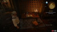 You can find the key you need on a book along the northern end of the room.